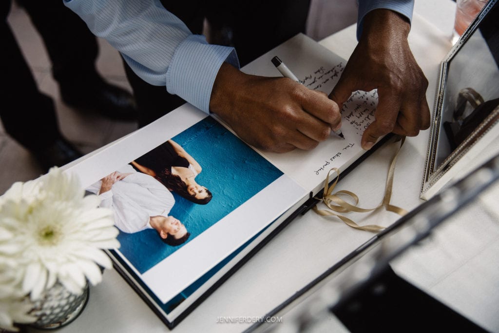 photo of an engagement album that shows printed photos and signatures sitting on table