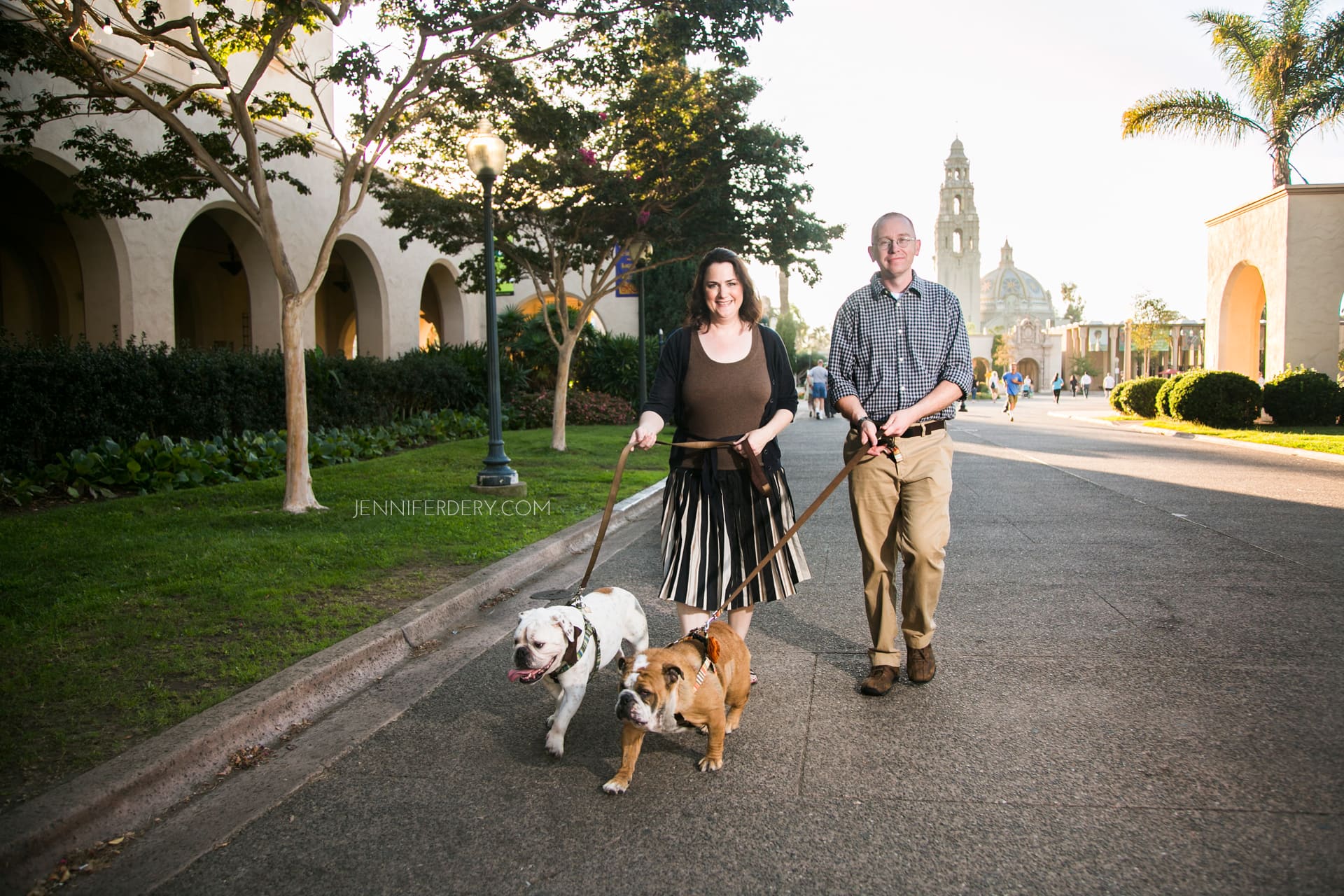 family pet photography in balboa park with two rescue bulldogs, one white, one brown and their doggie parents