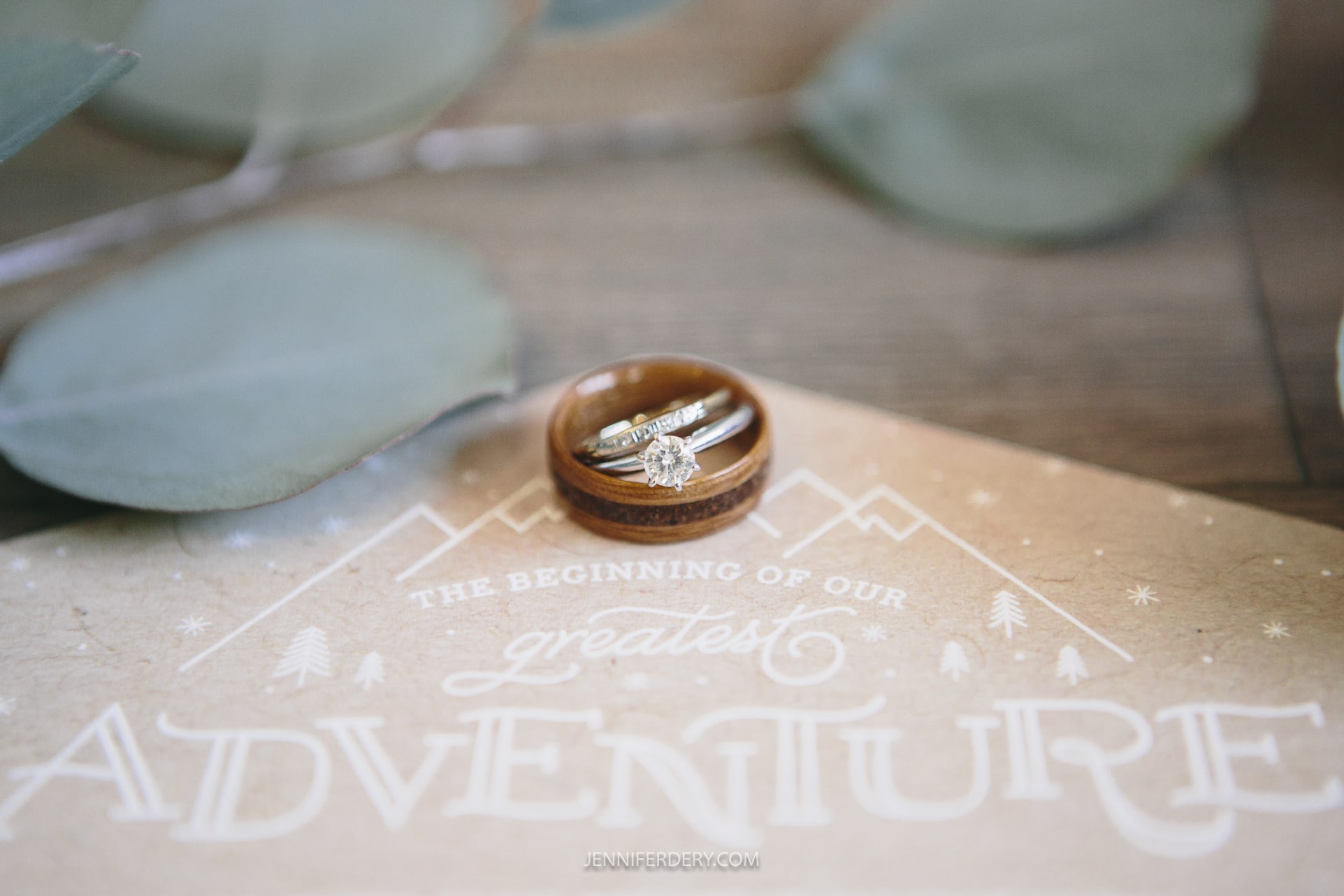 using a macro lens to photograph nested wedding rings sitting on a wedding invitation