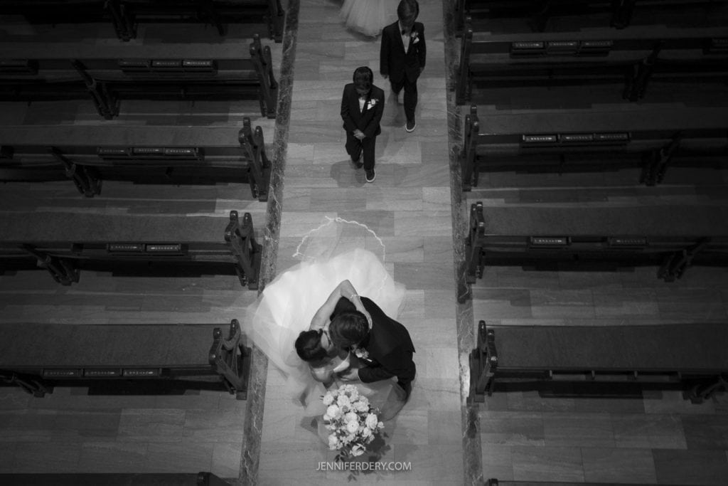 wedding photos in black and white  of a bride and groom kissing in the middle of the aisle recessional at Founders Chapel 