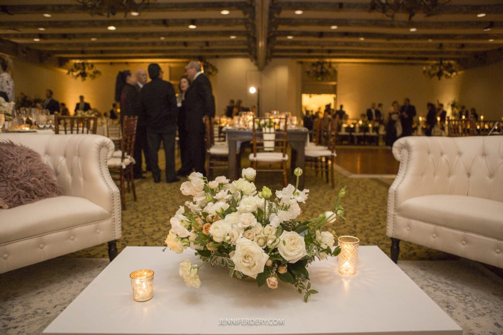 rancho bernardo inn wedding decor photos in ballroom showing white flowers and lots of candles and two white couches for the lounge area