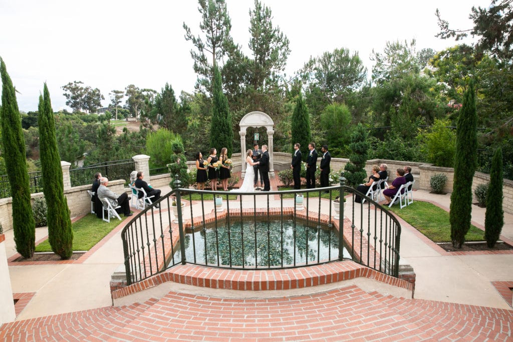 a wedding party at the prado wishing well during a wedding ceremony. bride wondered how to inquire about a wedding photographer as well