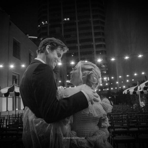black and white photo of a bride and groom outside of the guild hotel at night