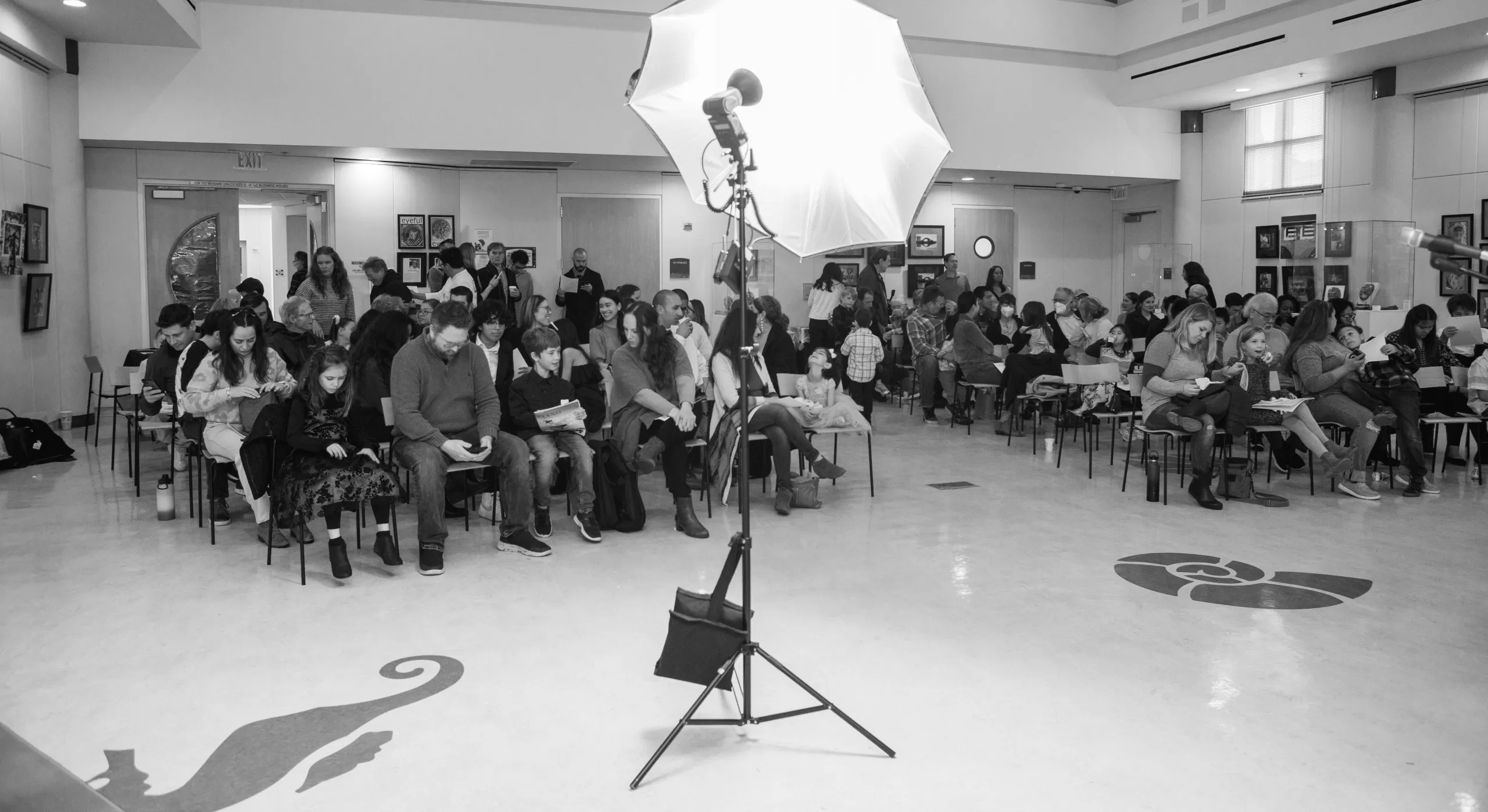 getting started as a photographer setting up lighting at a music recital in a room full of waiting parents