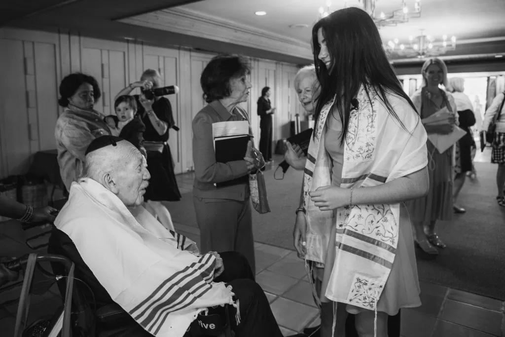 black and white photo of bat mitzvah girl chatting with her grandfather
