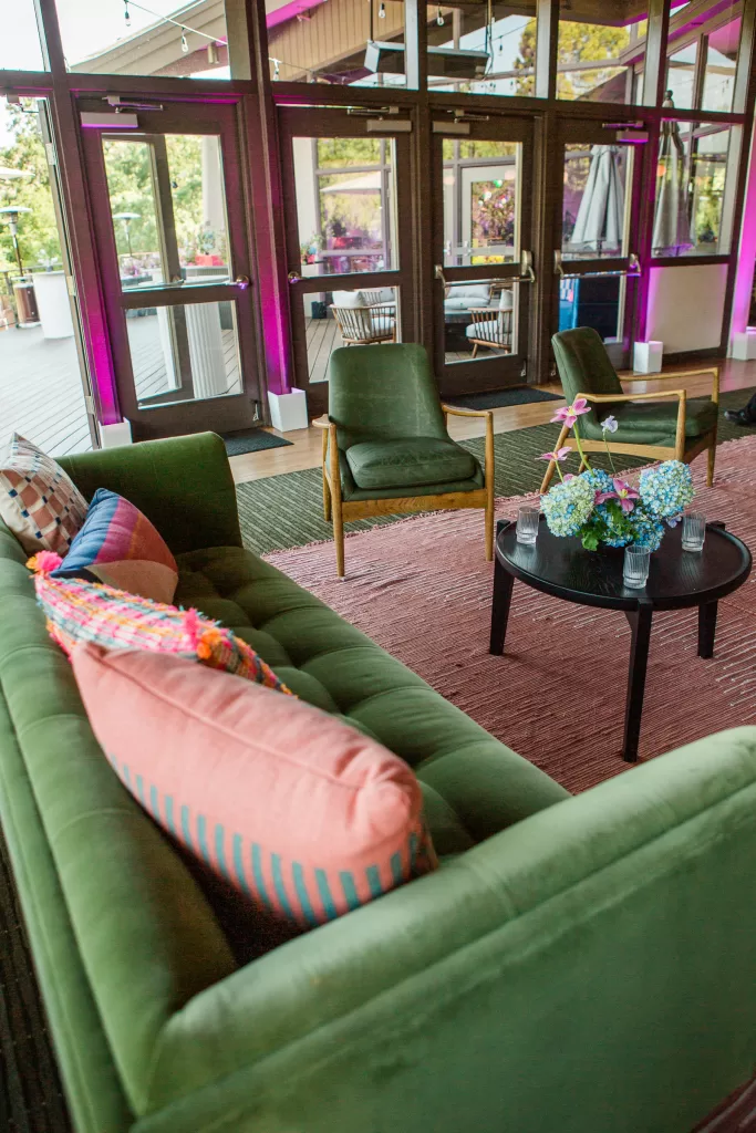 photo of a green couch with salmon pink pillows used as a setting area at a reception at the university club in palo alto bat mitzvah