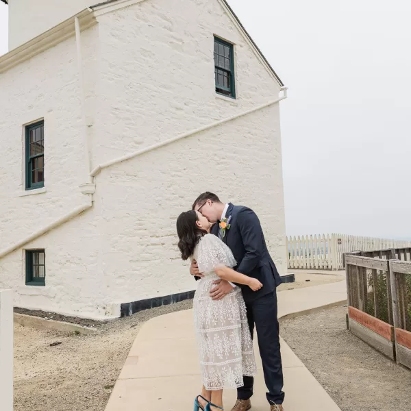 wedding photos at cabrillo national monument lighthouse. Bride and groom kissing at the lighthouse before their elopement