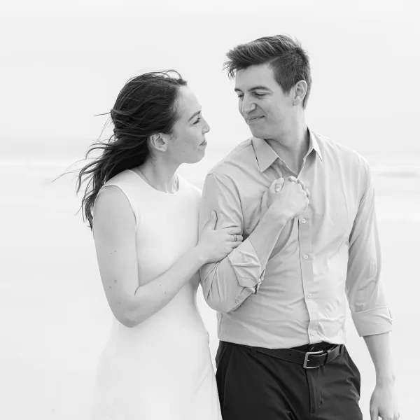 black and white photo of an engagement session couple arm-in-arm at the beach in Coronado, Ca