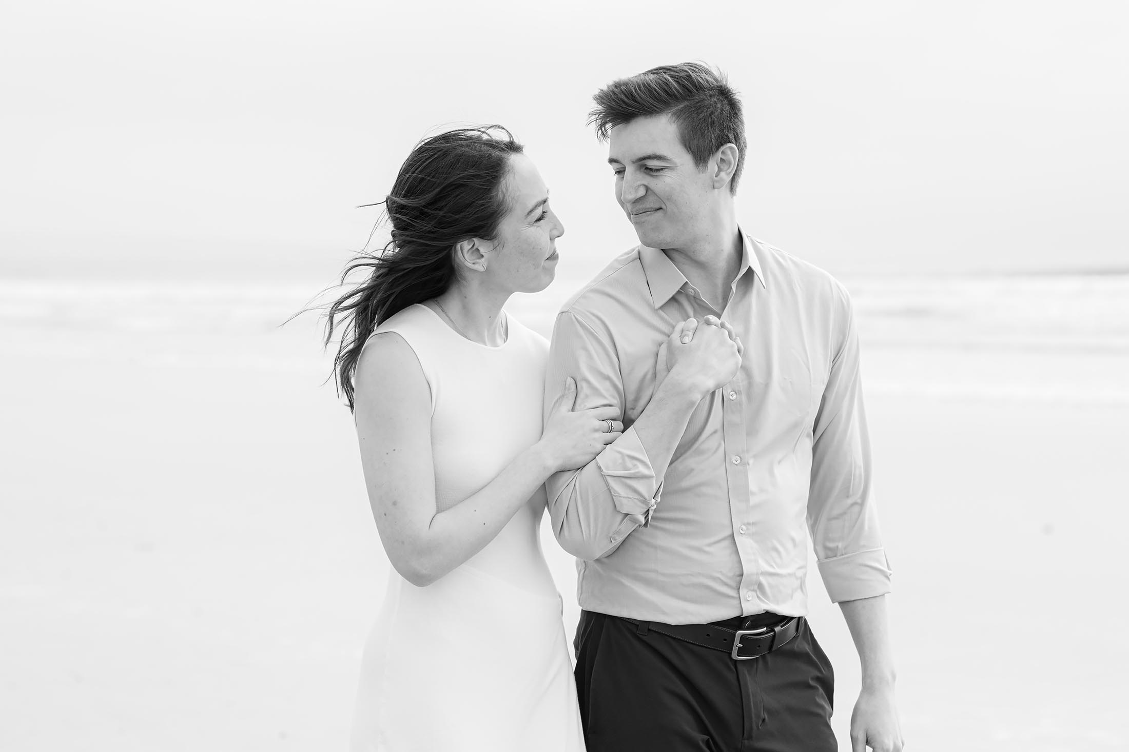 black and white photo of an engagement session couple arm-in-arm at the beach in Coronado, Ca