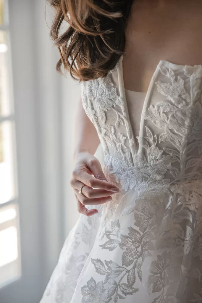 detail photo of a white wedding dress with floral applique