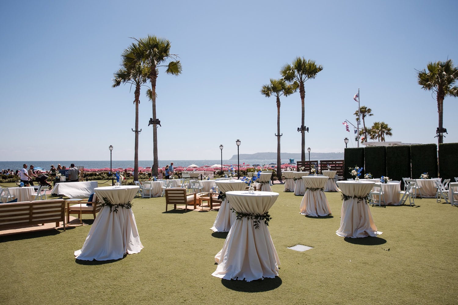 wedding cocktail hour set up on grand lawn at the hotel del in navy, white, and brown with ocean view