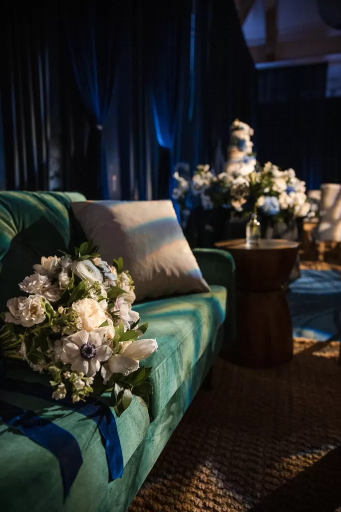 white floral arrangements, fairy lights, green couch, and navy draped ballroom of southpointe ballroom at the hotel del coronado, CA