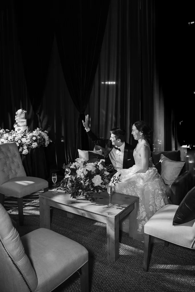 couple waving to friends while in a seating area designed for the ballroom of southpointe ballroom at the hotel del coronado, CA